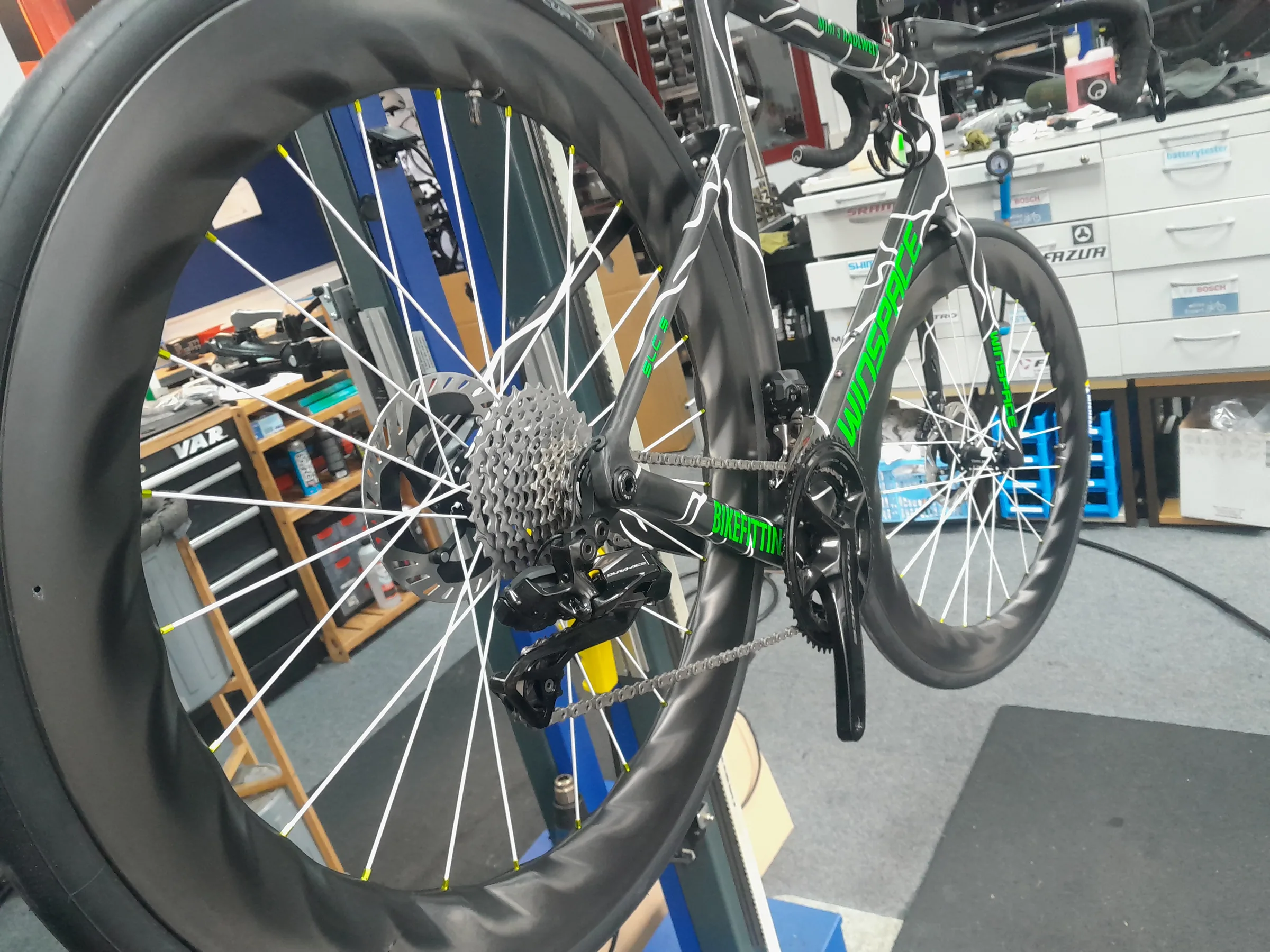 Rennrad mit Radlwelt-Schriftzug im Montageständer der Werkstatt